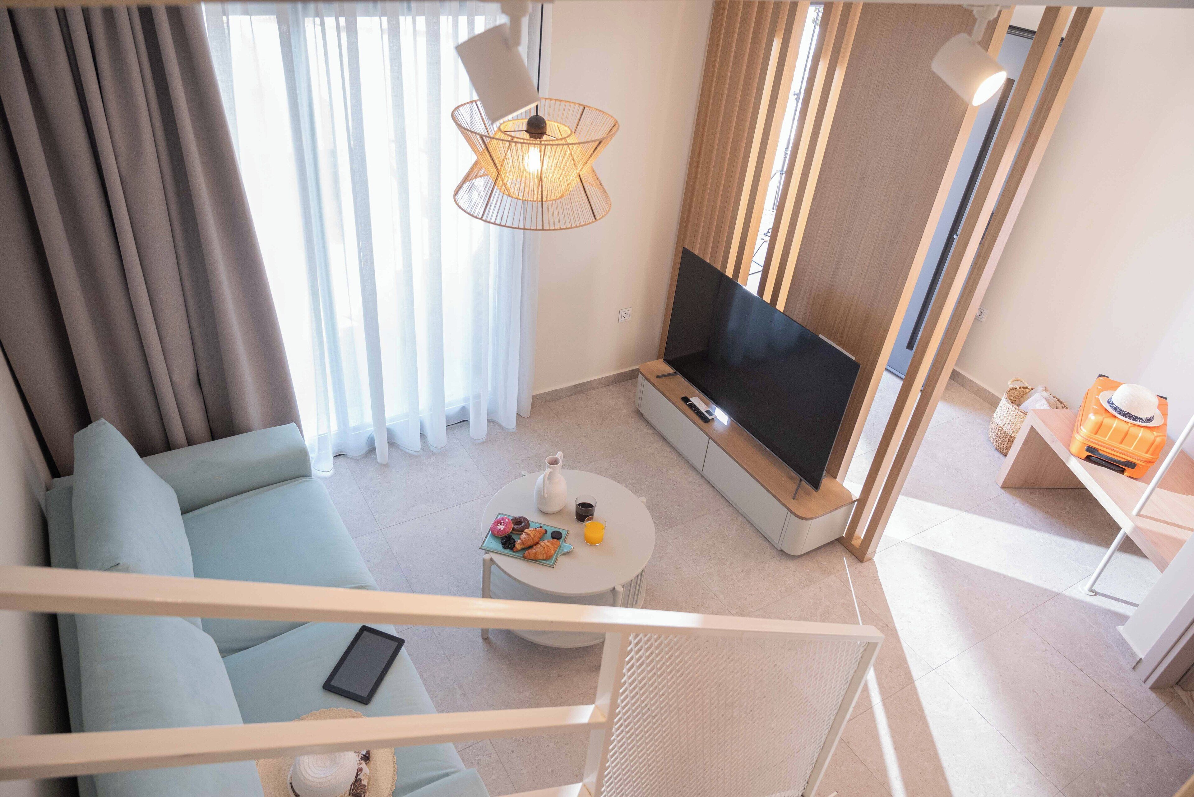 Un salon moderne comprenant un canapé, un téléviseur, une table basse et un coin repas.