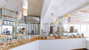 Un comptoir de buffet proposant une variété de plats, des vitrines réfrigérées et des lampes suspendues décoratives.