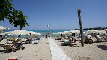 Pantai pribadi, kursi berjemur, payung pantai, dan handuk pantai