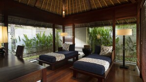 A room with two beds, a table, and a chair.