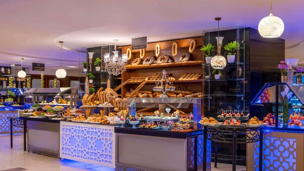 Un rayon boulangerie où sont présentés divers produits de boulangerie et pâtisseries sur des étagères et des comptoirs.