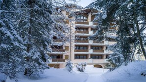 A multi-story building surrounded by snow-covered trees. - Chalet Belmont Hotel (Flims)