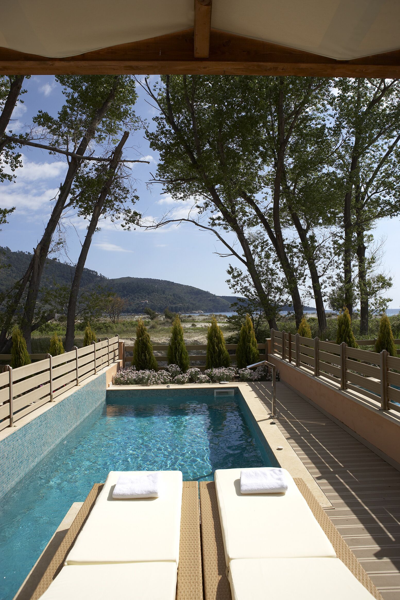 A pool area with lounge chairs and a view of the landscape.