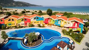 A resort with colorful buildings, a swimming pool, and a beach view. - Alexandra Golden Boutique Hotel (Thasos)