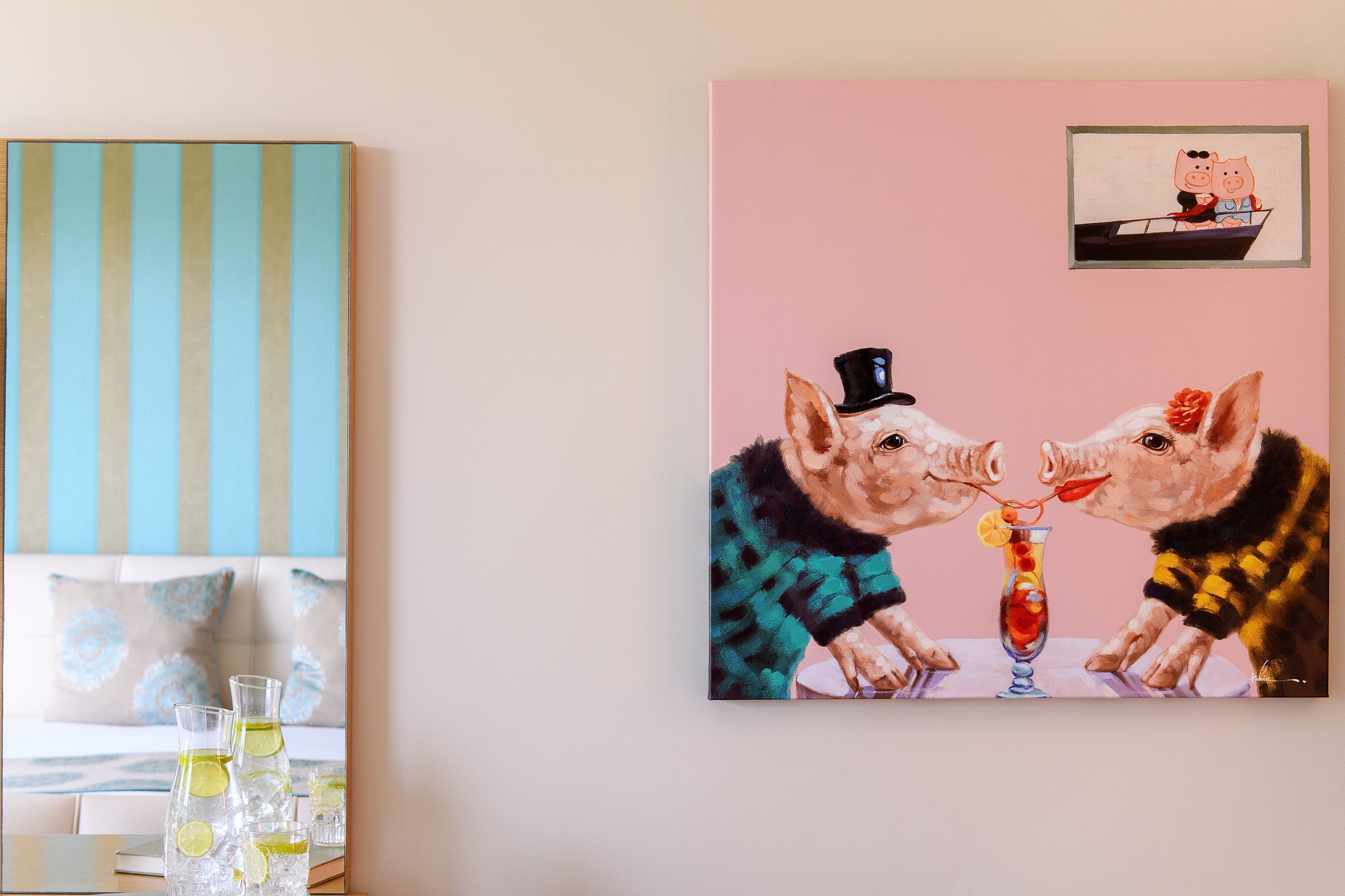 Una pintura que muestra dos cerdos sentados a una mesa con bebidas, un pared a rayas y un cuadro enmarcado arriba.