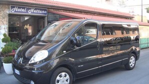 A black van parked in front of a building with a sign that reads "Hotel Nettuno." - Hotel Nettuno (Diano Marina)