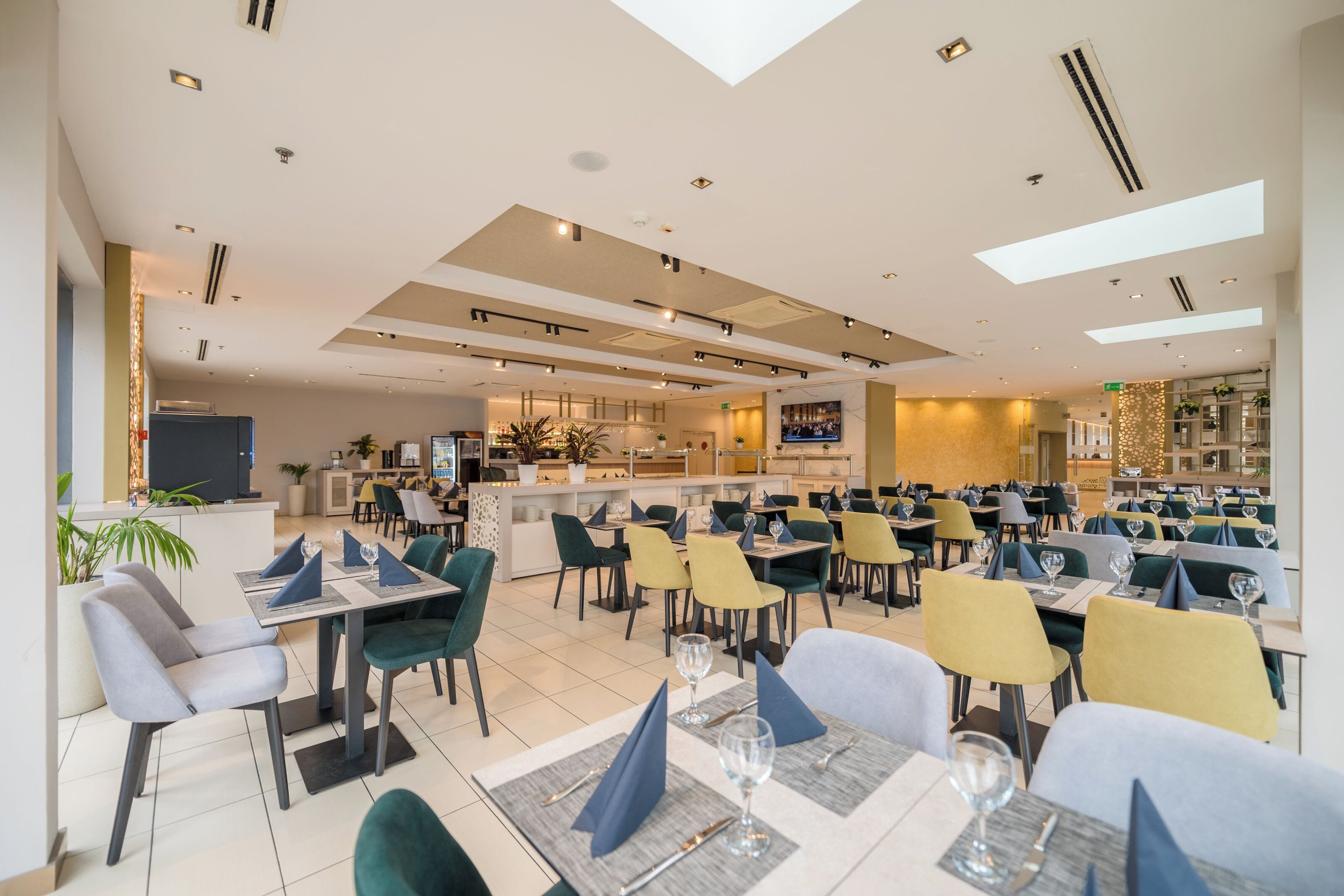 Un restaurante moderno con una barra central, varias mesas para comer y una diversidad de sillas.