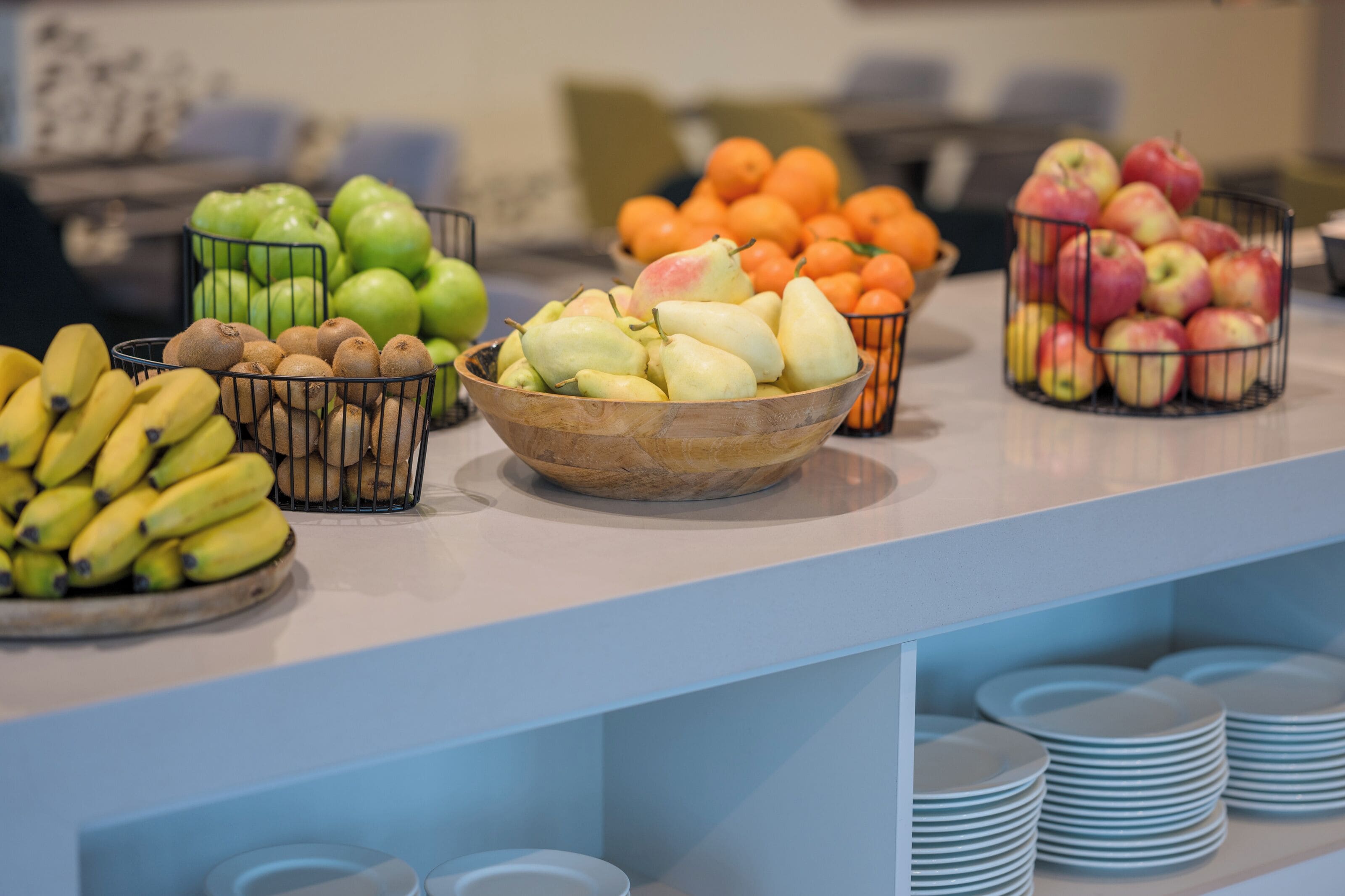 A buffet with various fruits and bananas arranged on a counter.