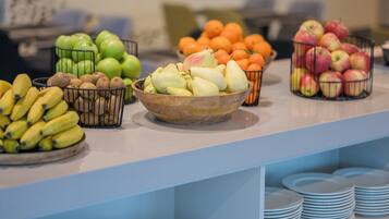 A buffet with various fruits and bananas arranged on a counter.