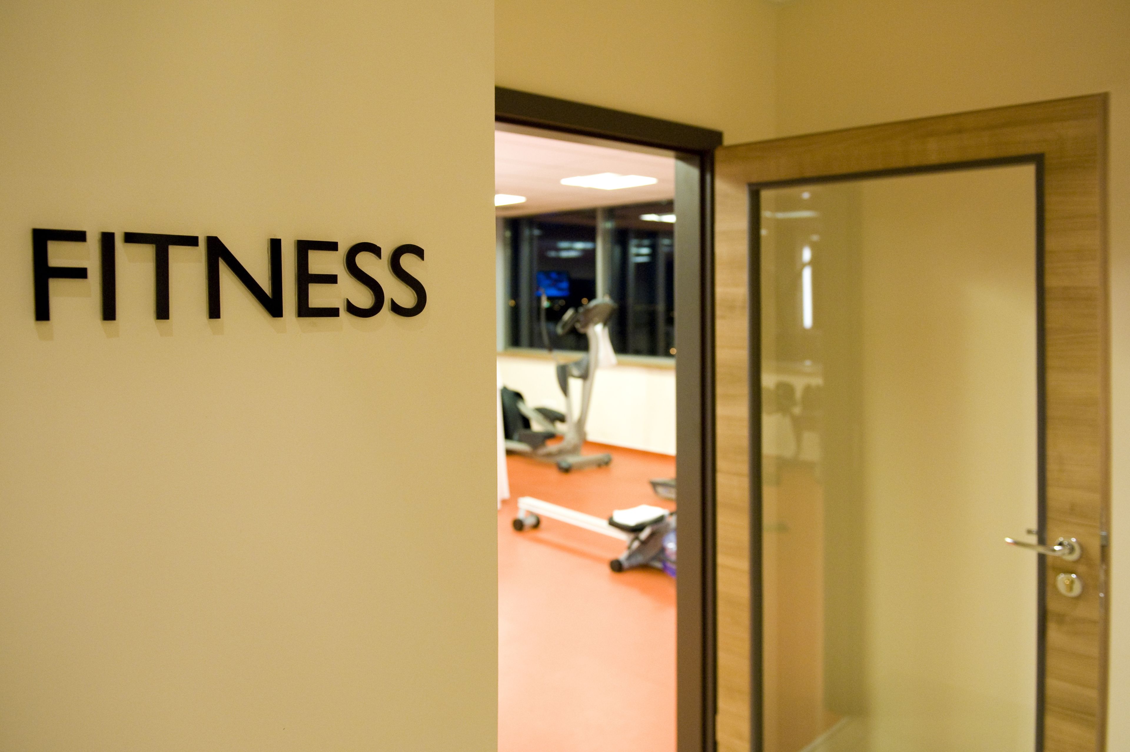 Un centre d'entrenament amb un cartell que diu "FITNESS" a la paret.