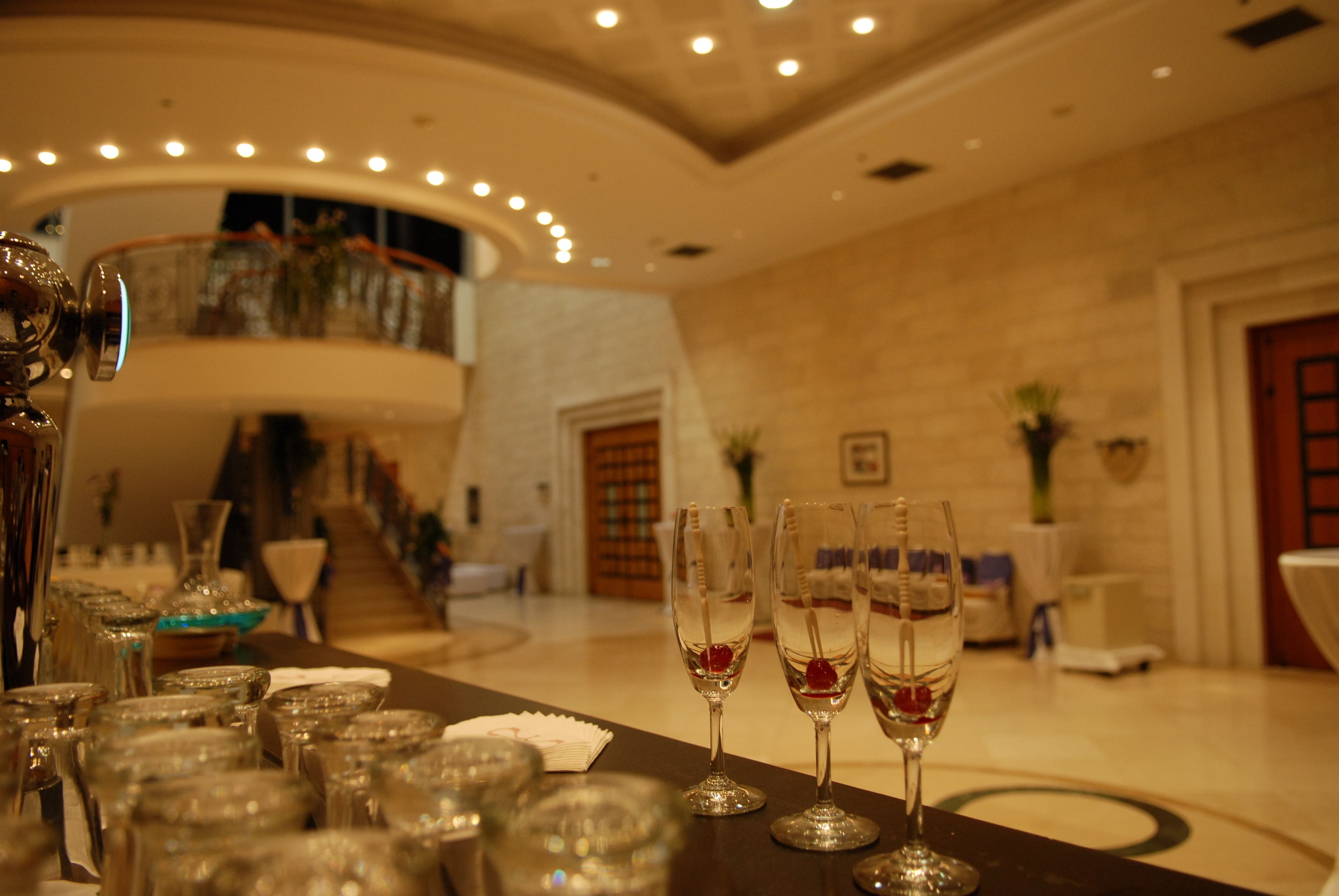 A luxurious hotel lobby with a grand staircase, elegant glassware, and a well-lit ambiance.