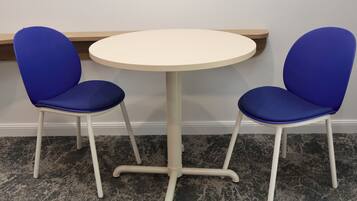 A small round table with two blue chairs.