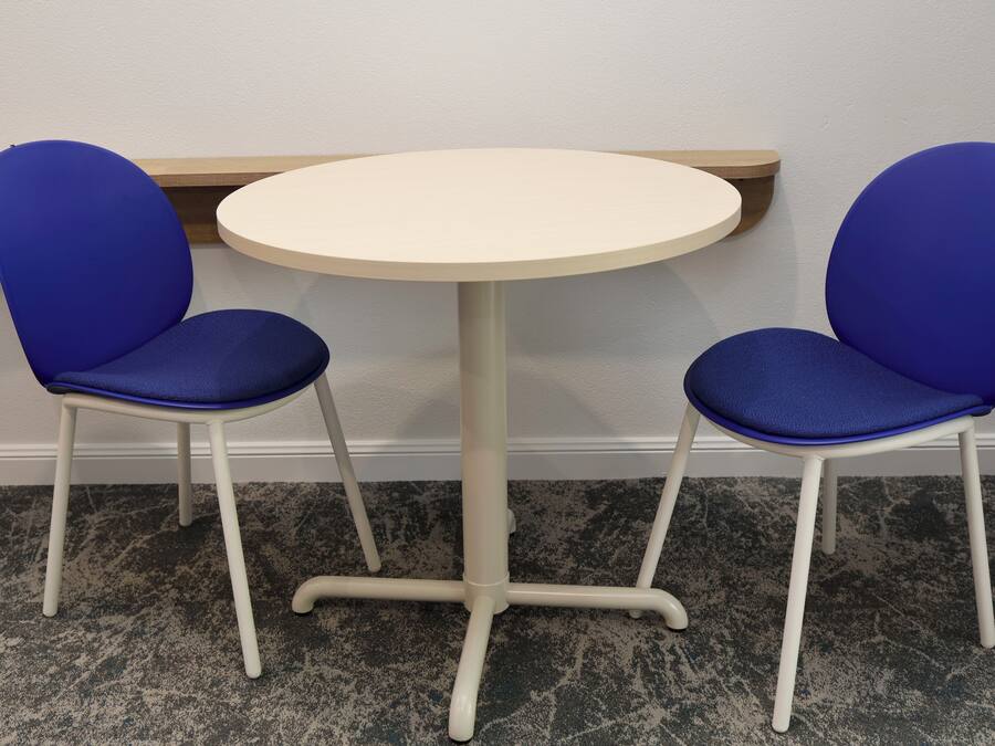 A small round table with two blue chairs.