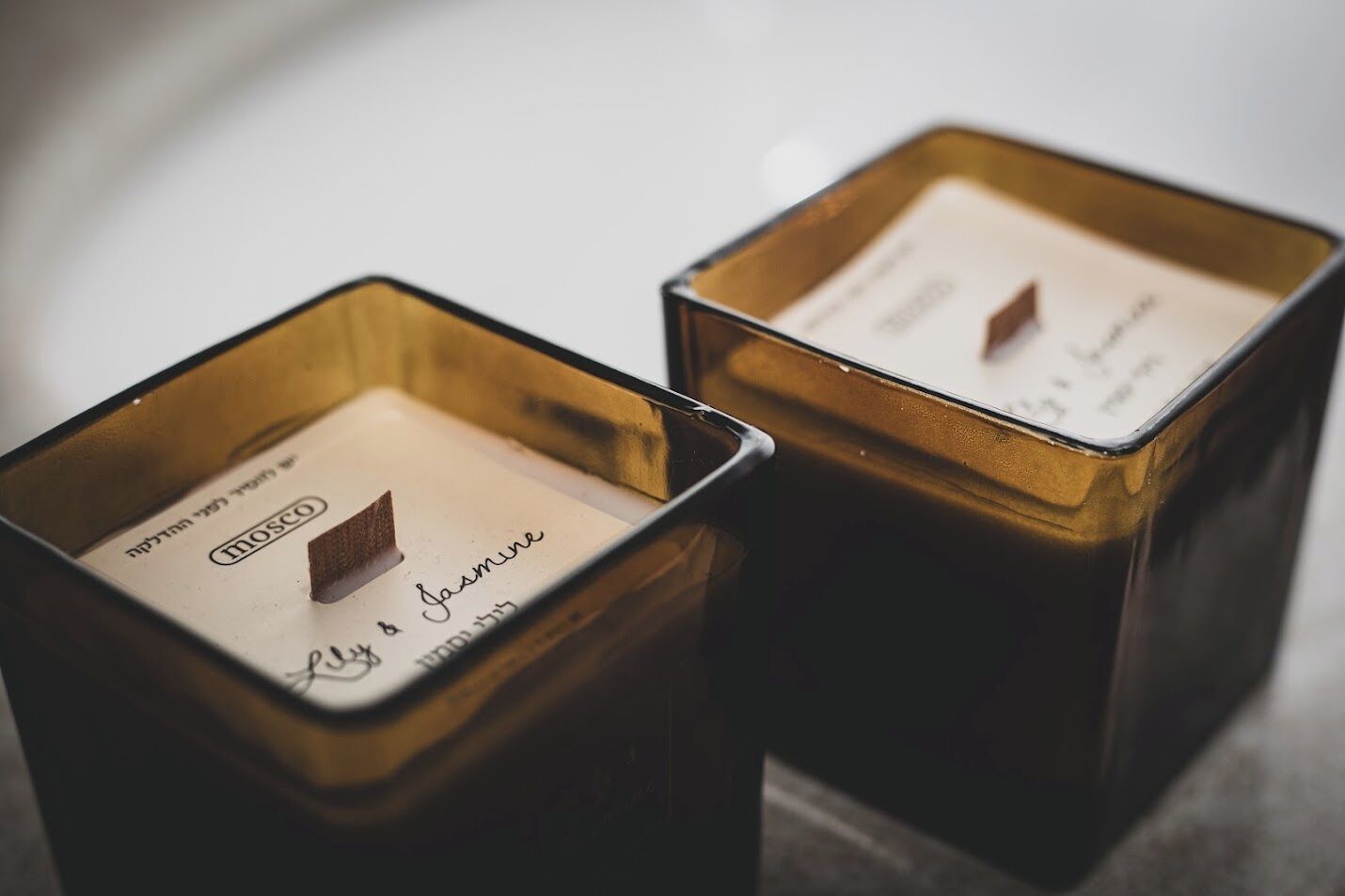 Deux bougies carrées, chacune avec une étiquette à l’intérieur.
