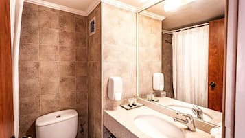 Une salle de bain avec des toilettes, un lavabo et un miroir.