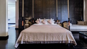 A modern bedroom with a large bed, a hanging chair, and a sofa. - Aruntara Riverside Boutique Hotel (Chiang Mai)