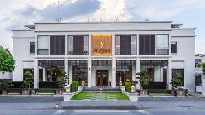 A modern hotel with a symmetrical facade, large windows, and a central entrance with steps leading up to the door. - Aruntara Riverside Boutique Hotel (Chiang Mai)