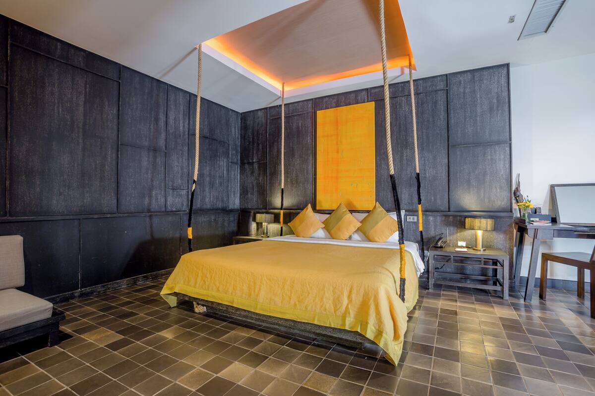 Una habitación de hotel moderna con una cama grande, un escritorio y una silla.