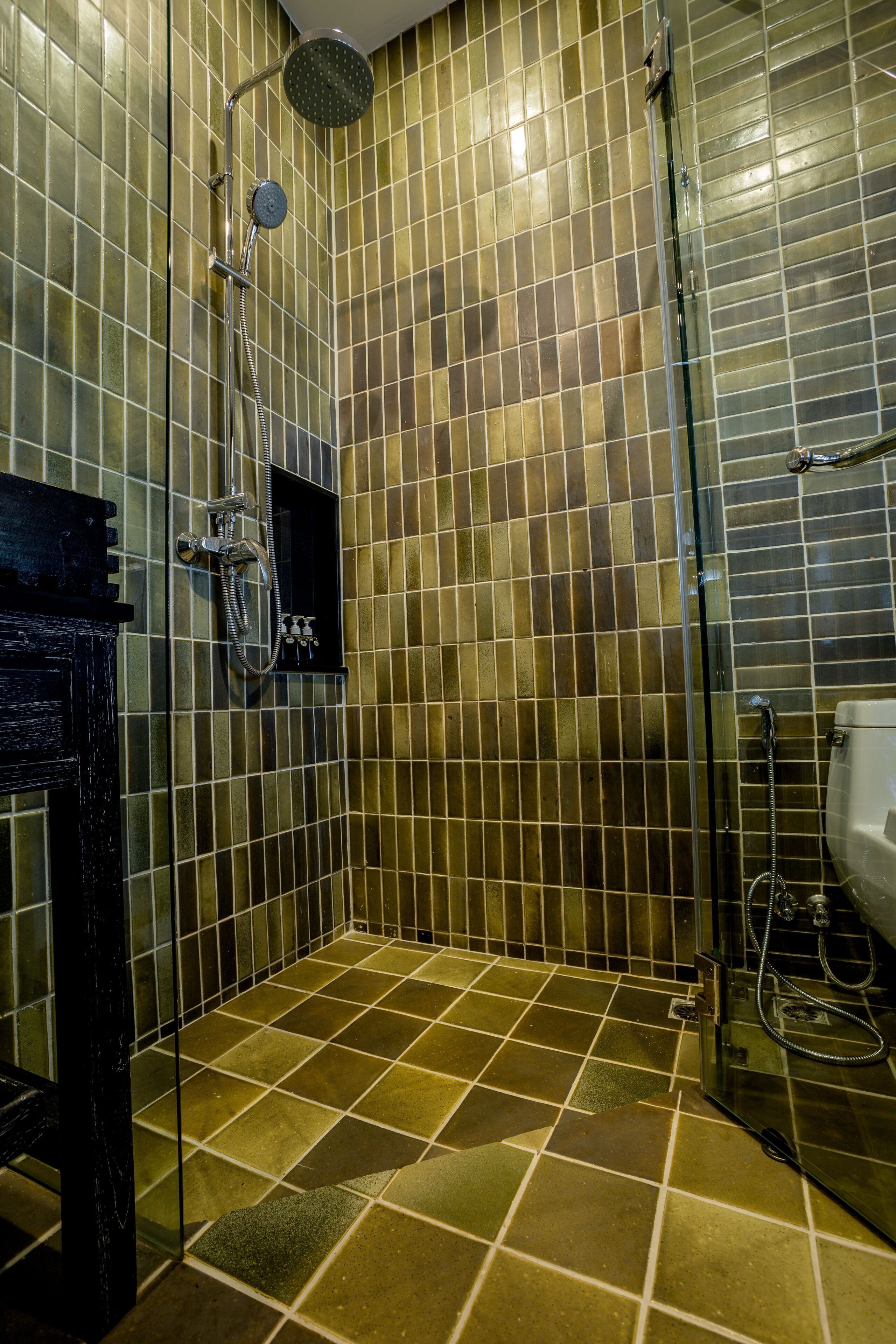 A bathroom with a shower, tiled walls, and a toilet.