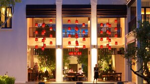 A hotel with a modern design, featuring a two-story structure, large windows, and a well-lit entrance. - Aruntara Riverside Boutique Hotel (Chiang Mai)
