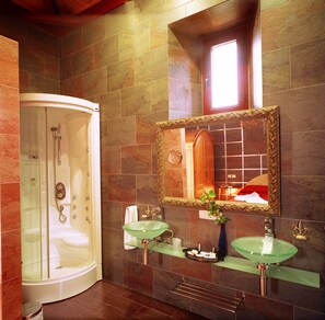 A bathroom with a walk-in shower, two sinks, and a large mirror. - Palacio de la Serna (Ballesteros de Calatrava)