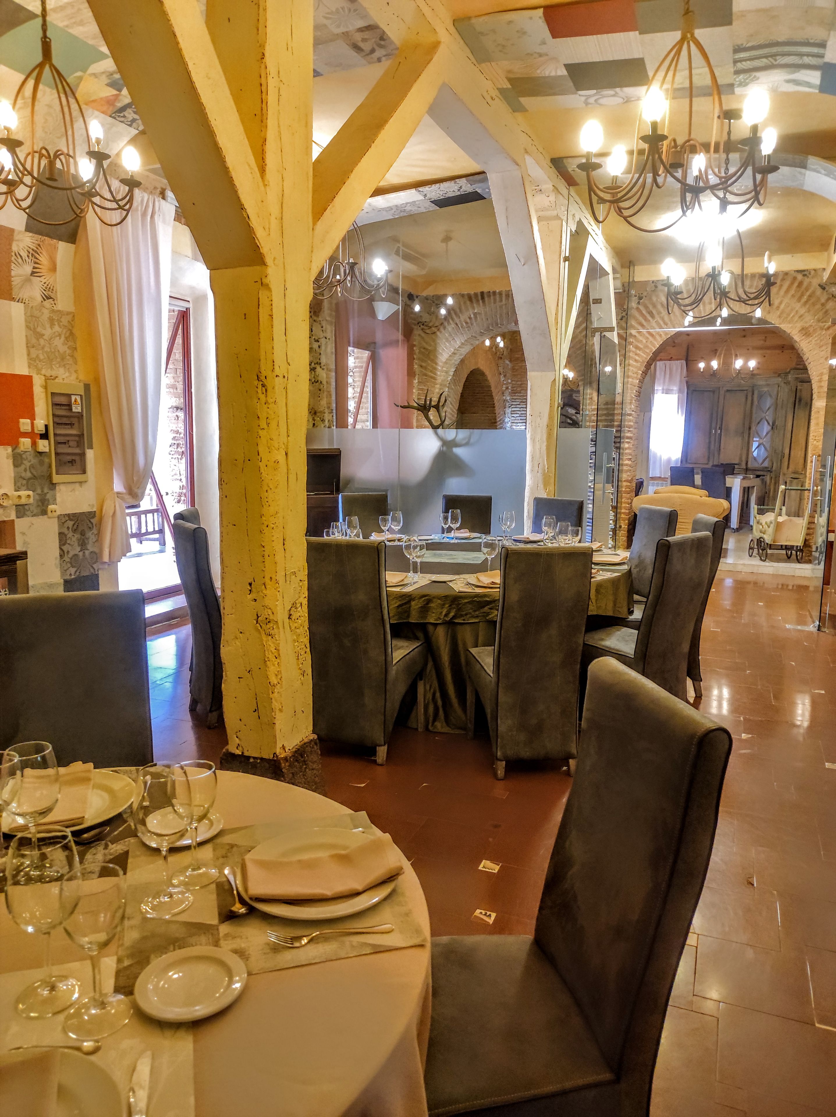 Un restaurante con mesas redondas, sillas y candelabros.
