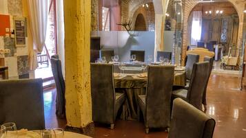 Un restaurante con mesas redondas, sillas y candelabros.