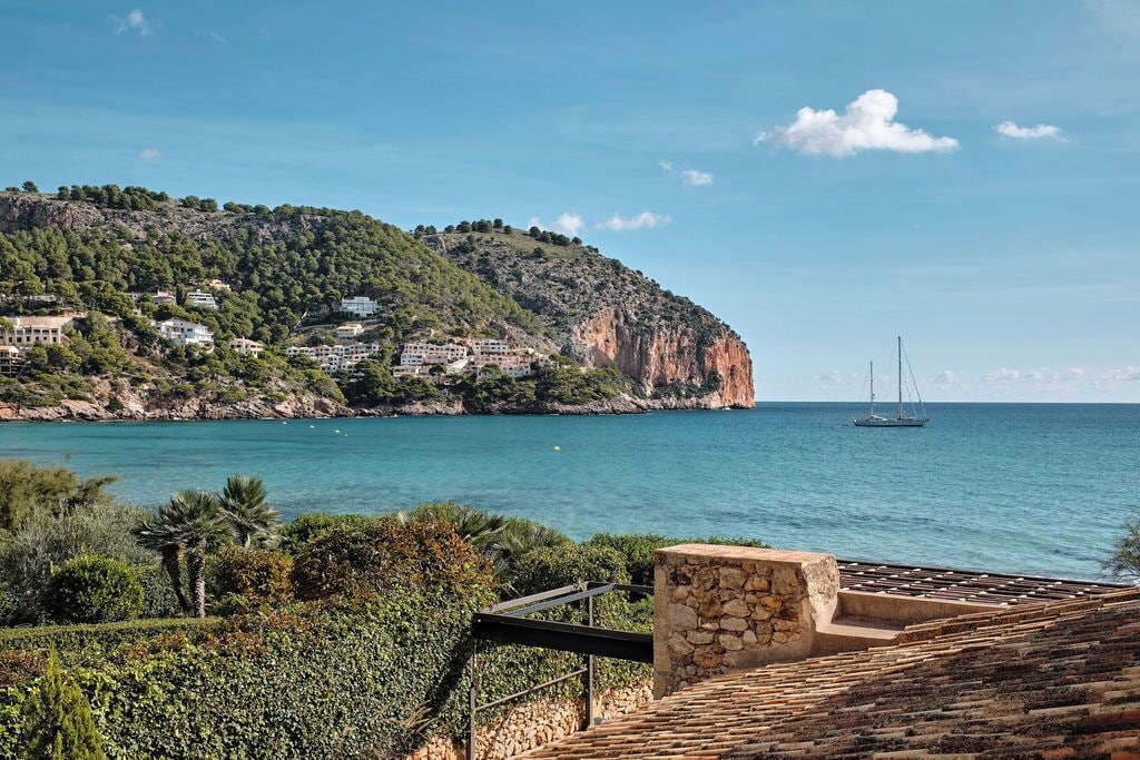 A coastal view with a stone staircase leading to a terrace overlooking the sea.