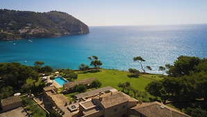 Una propiedad costera con piscina, edificios escalonados y vistas al mar.