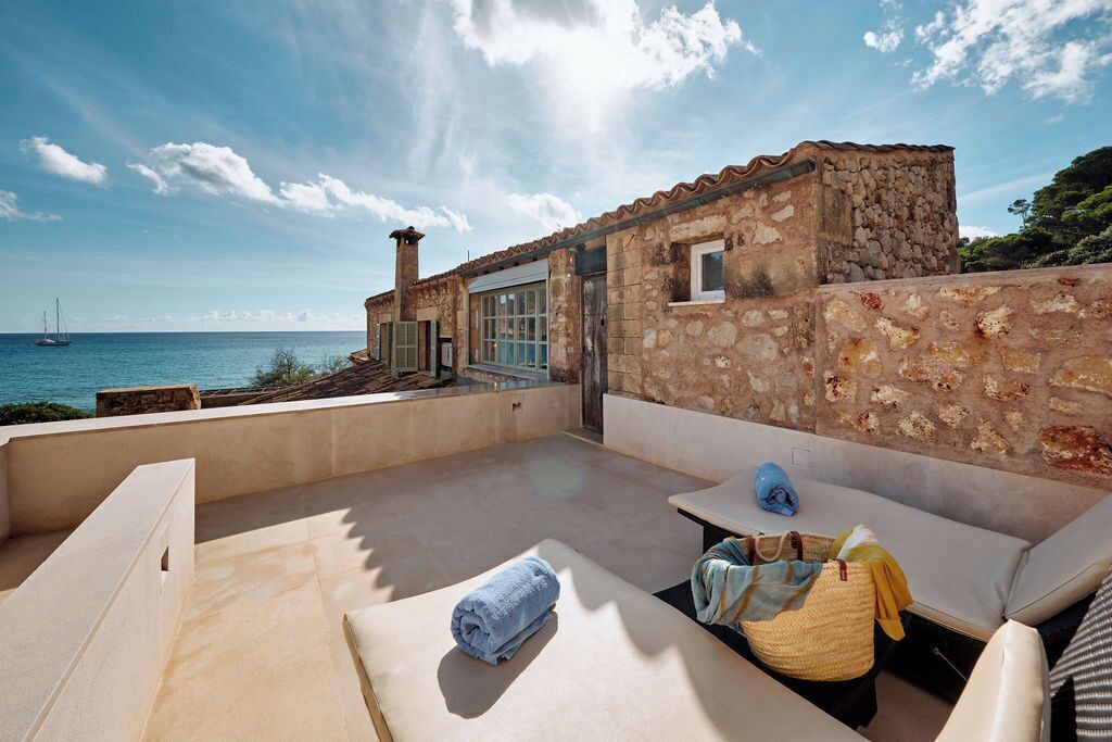 Un edificio de piedra con una terraza con vistas al mar.
