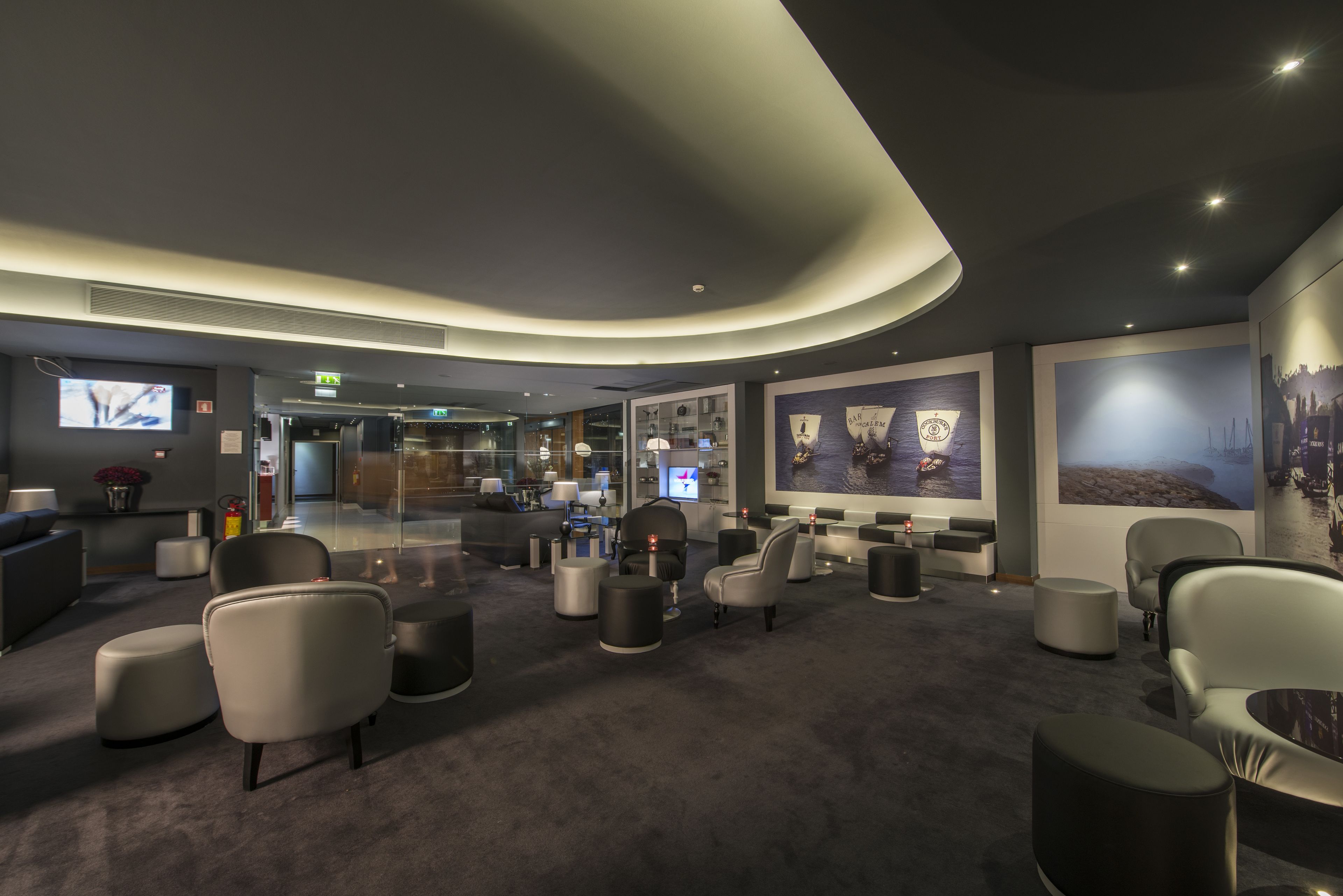 A modern hotel lobby with seating areas, a reception desk, and artwork on the walls.