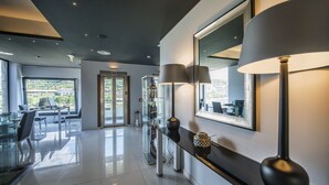 A modern hotel lobby with a glass partition, a reception desk, and a seating area with chairs and tables. - Vila Gale Collection Douro Hotel (Lamego)