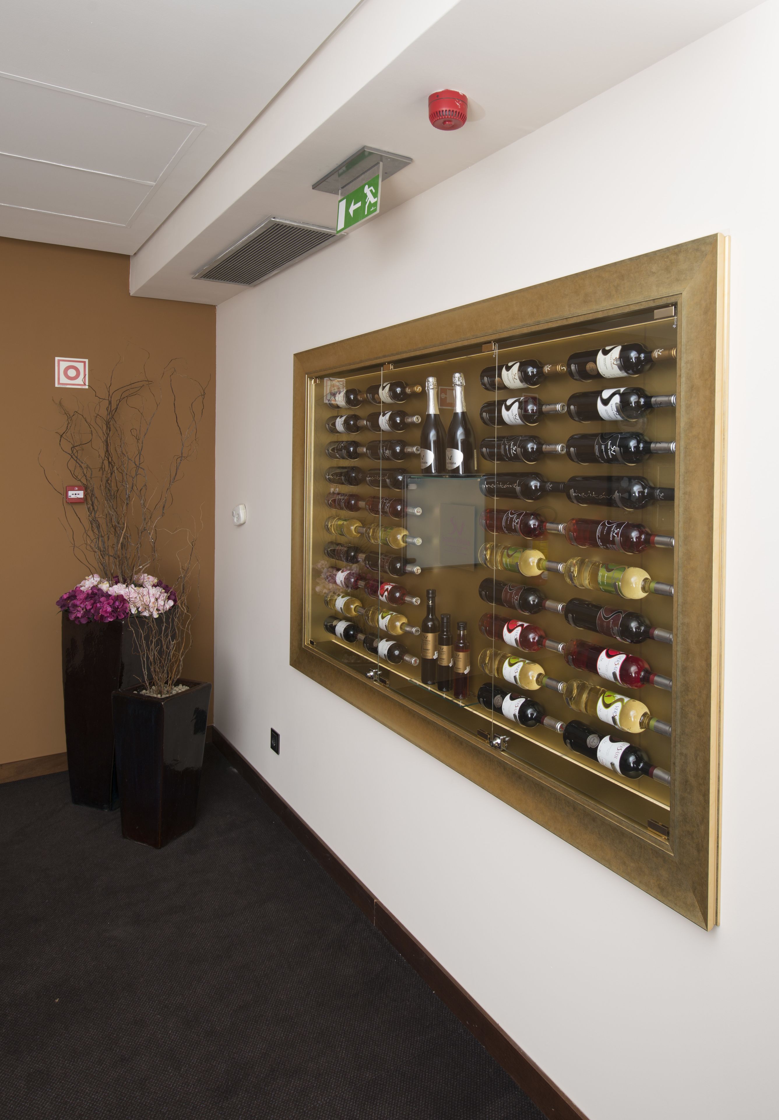 Una estantería de pared para varias botellas de vino.
