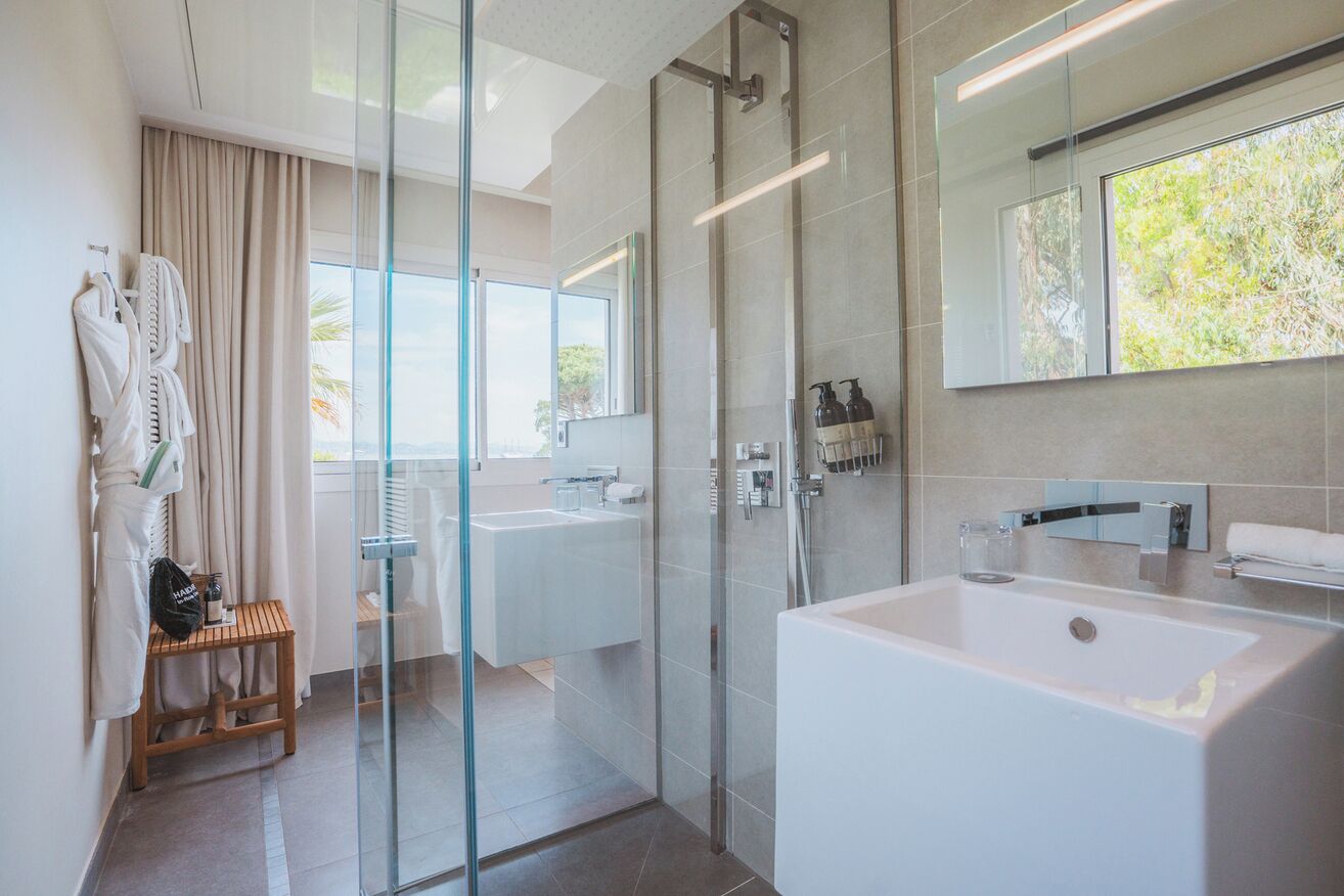 A modern bathroom with a glass shower enclosure, a large bathtub, and a dual sink vanity.