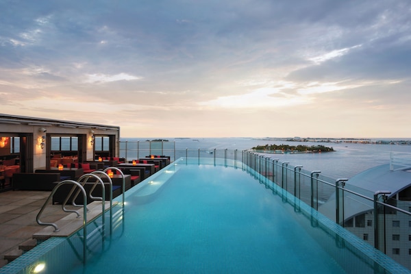 Una piscina al aire libre, sillones reclinables de piscina