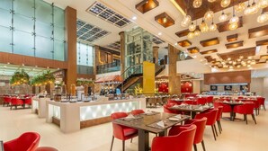 A spacious hotel lobby with a central island, red seating, and a modern staircase. - Country Inn & Suites by Radisson, Sahibabad, Distt Ghaziabad (U.P.) (Ghaziabad)