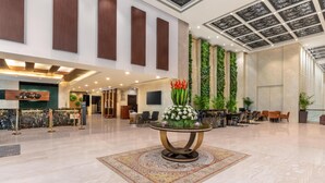 A spacious lobby with a reception desk, seating area, and a decorative table with flowers. - Country Inn & Suites by Radisson, Sahibabad, Distt Ghaziabad (U.P.) (Ghaziabad)