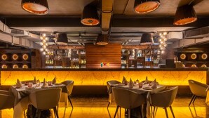 A restaurant with a bar area, tables set for dining, and a warm, ambient lighting. - Country Inn & Suites by Radisson, Sahibabad, Distt Ghaziabad (U.P.) (Ghaziabad)