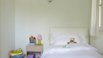 Restful retreat with a neatly made bed, bedside table, and reading materials.
