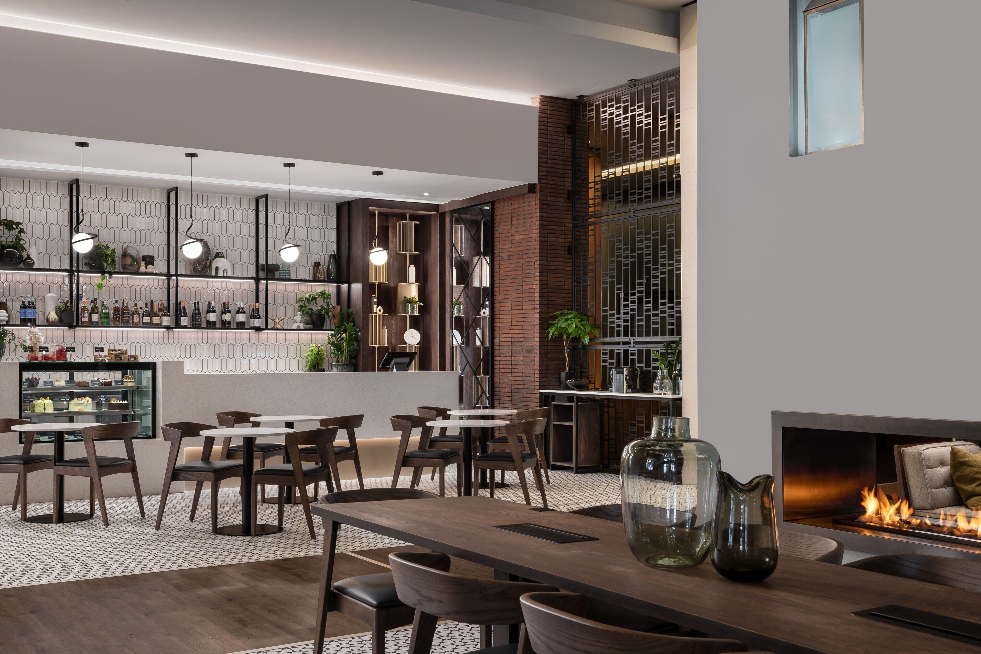 Un interior moderno con una zona de bar, asientos y una chimenea.