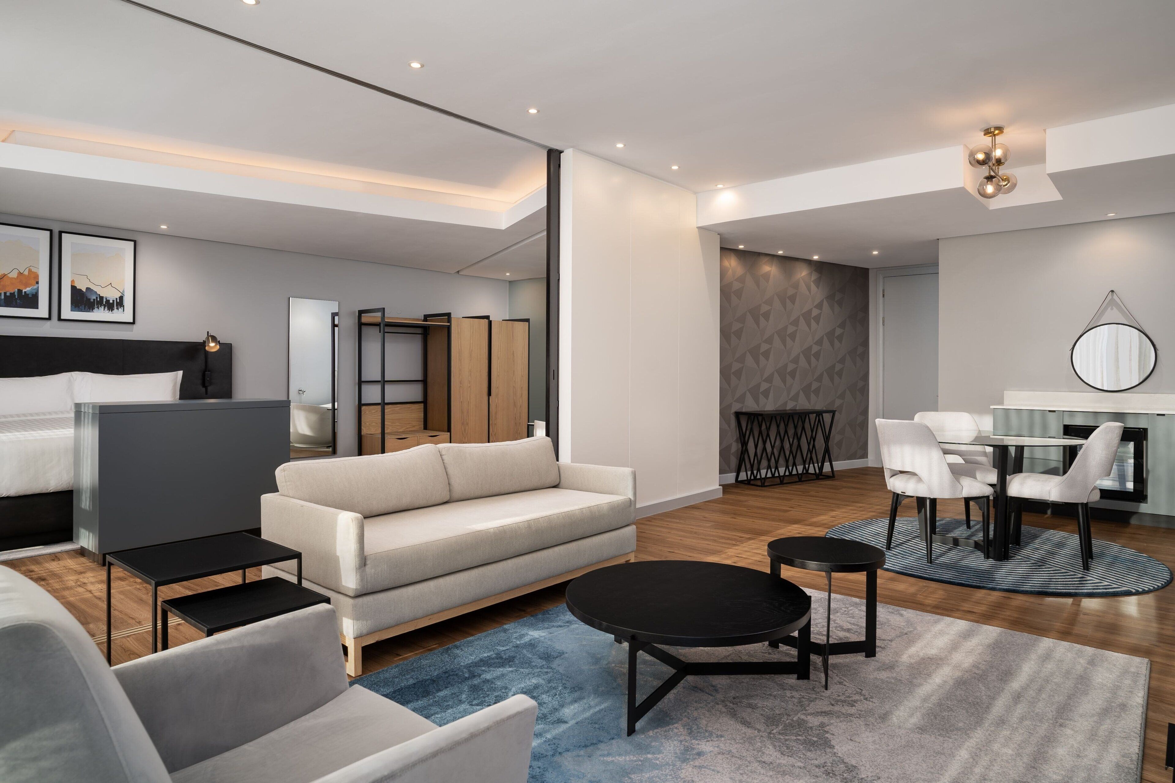 Uma sala de estar moderna com sofá, mesa de centro e área de jantar.