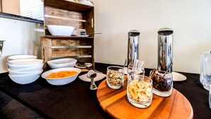 A breakfast buffet with bowls of cereal, fruits, and beverages on a wooden board. - Parkview On Hagley (Christchurch)