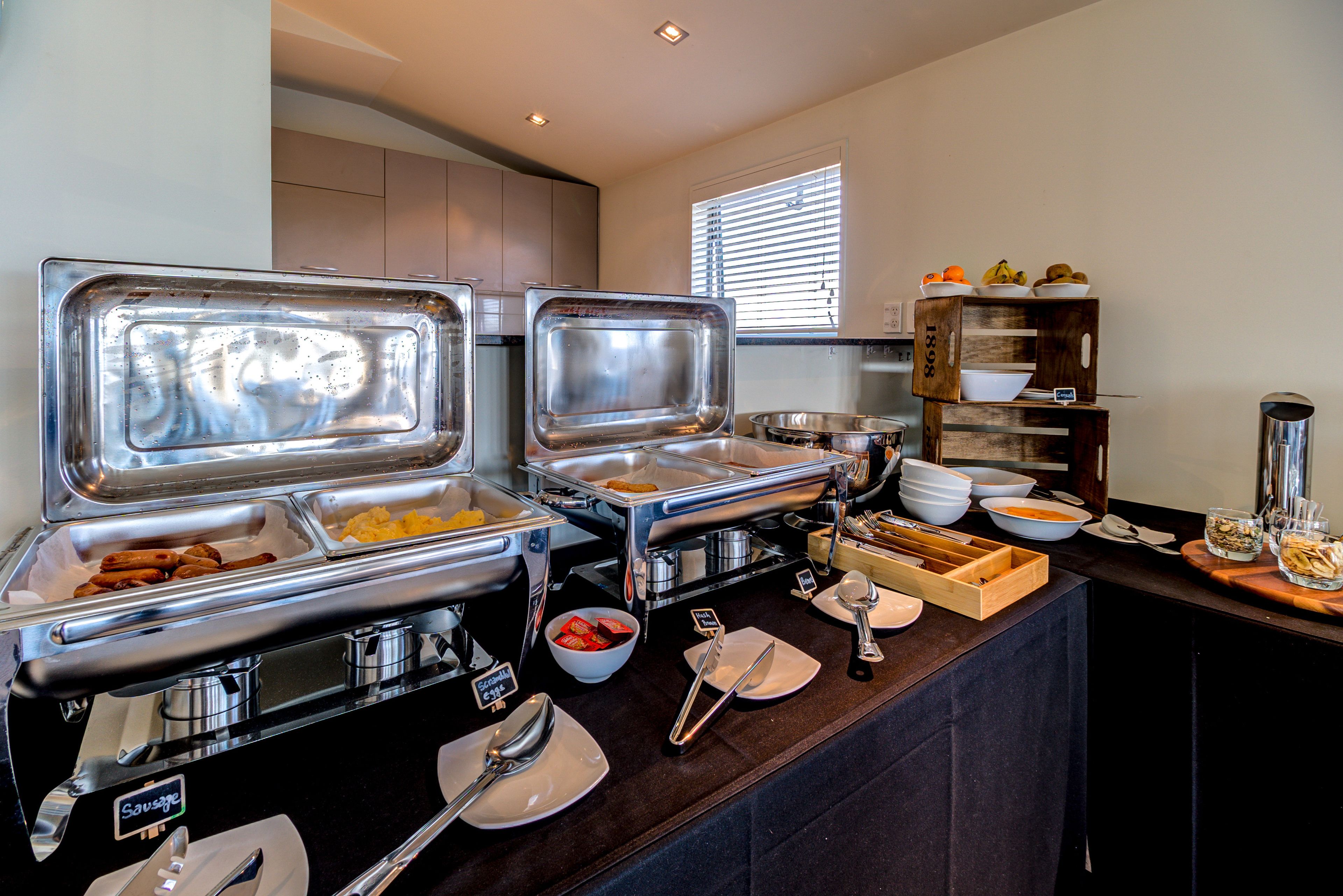 A buffet setup with various food items and utensils.