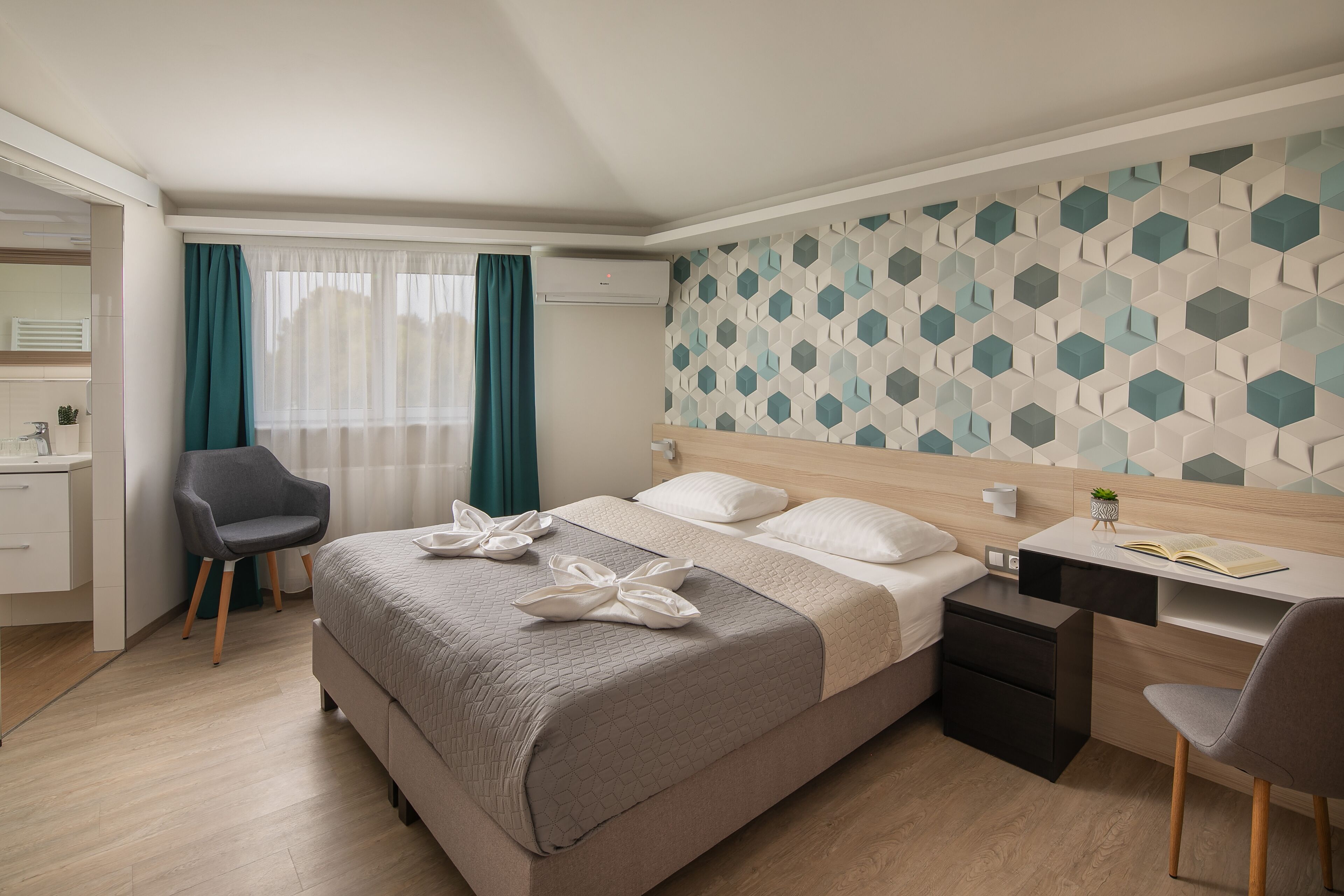 Een hotelkamer met een bed, een bureau, een stoel, een kledingkast en een badkamer.