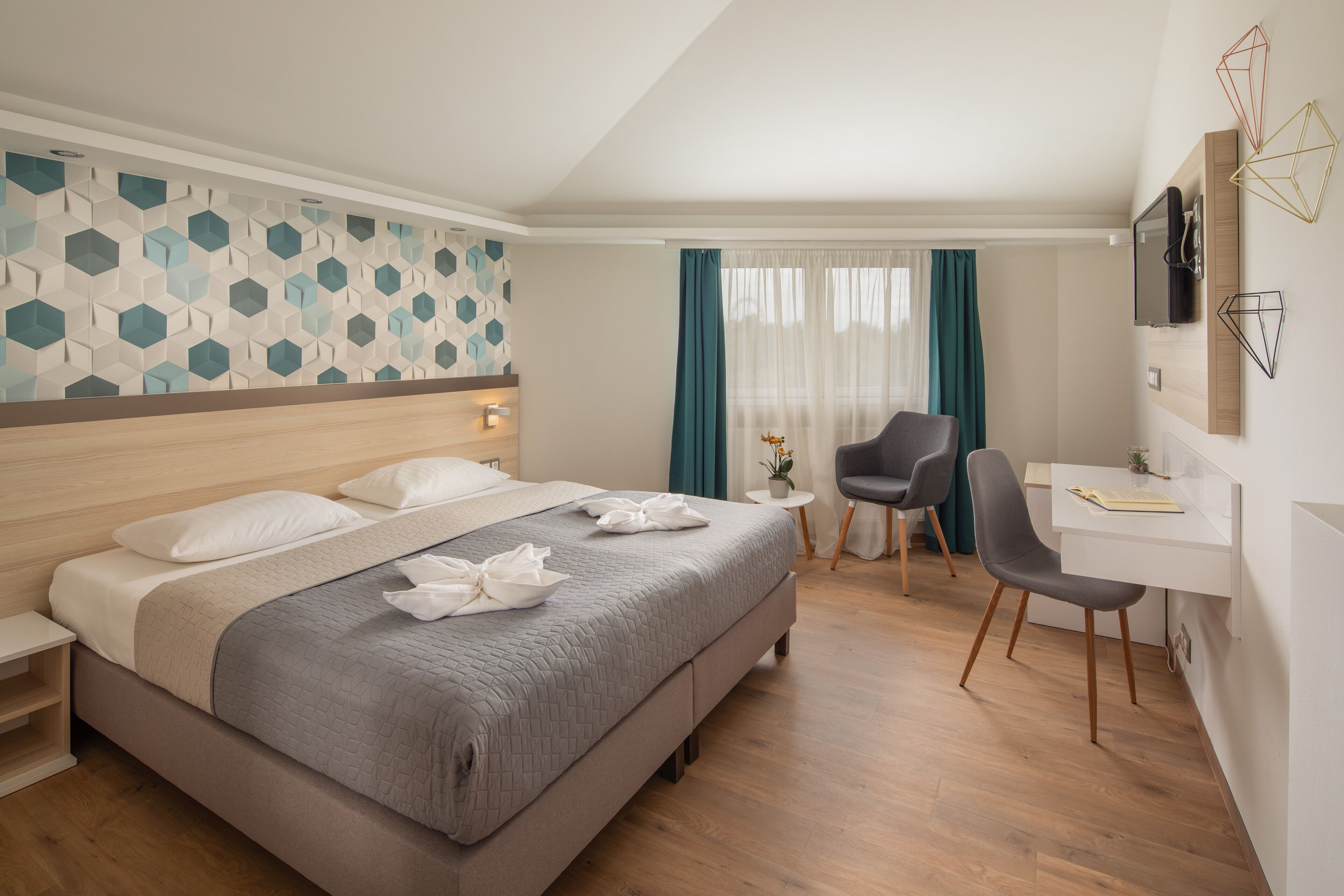 Une chambre d’hôtel avec un grand lit, un bureau et une chaise.