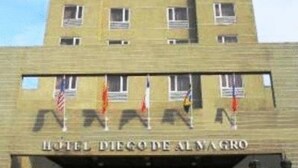 Een meerlaags hotelgebouw met een platte gevel en een bord waarop staat: HOTEL DIEGO DE ALMAGRO.