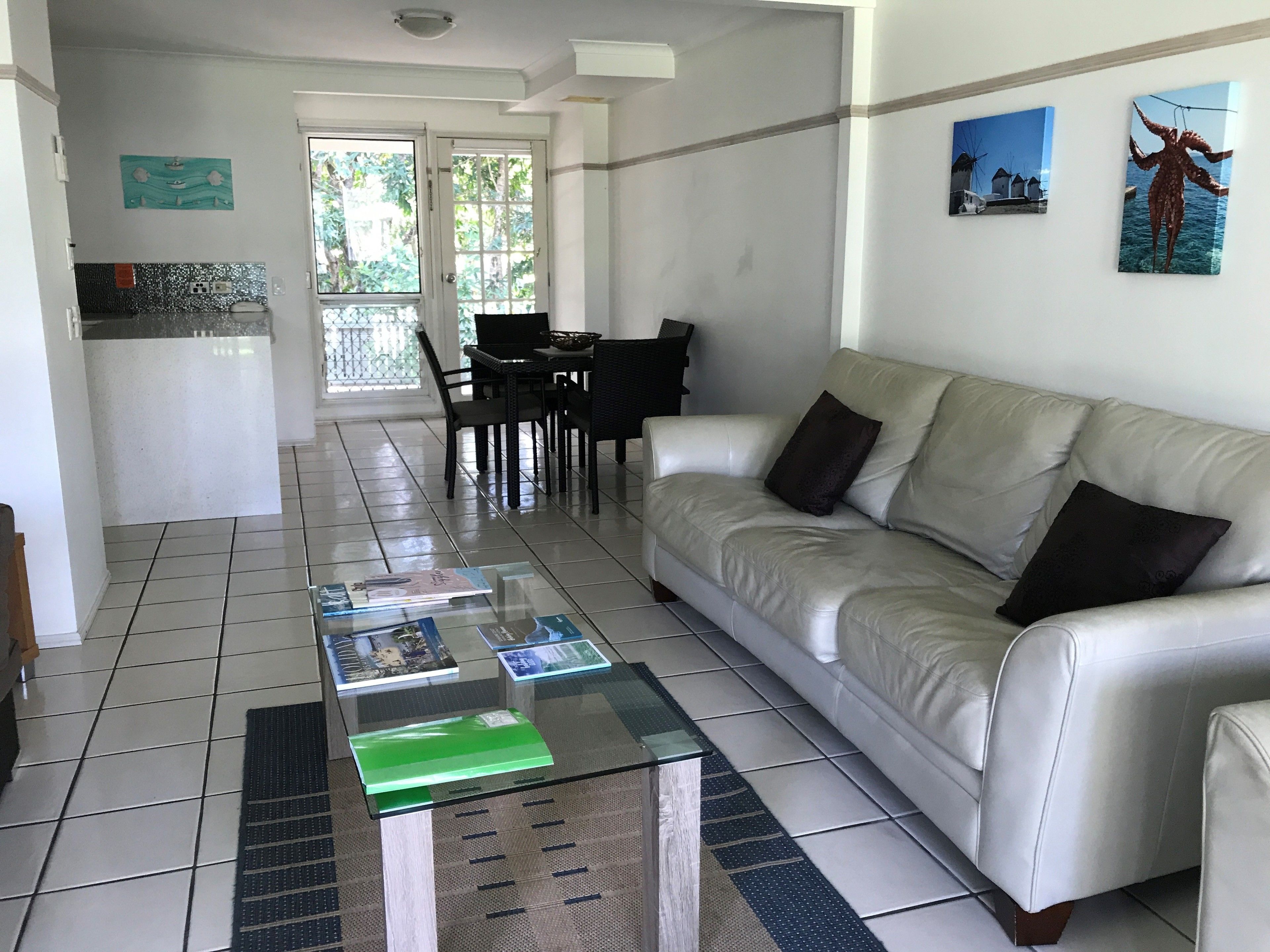 A living room with a sofa, coffee table, and dining area.