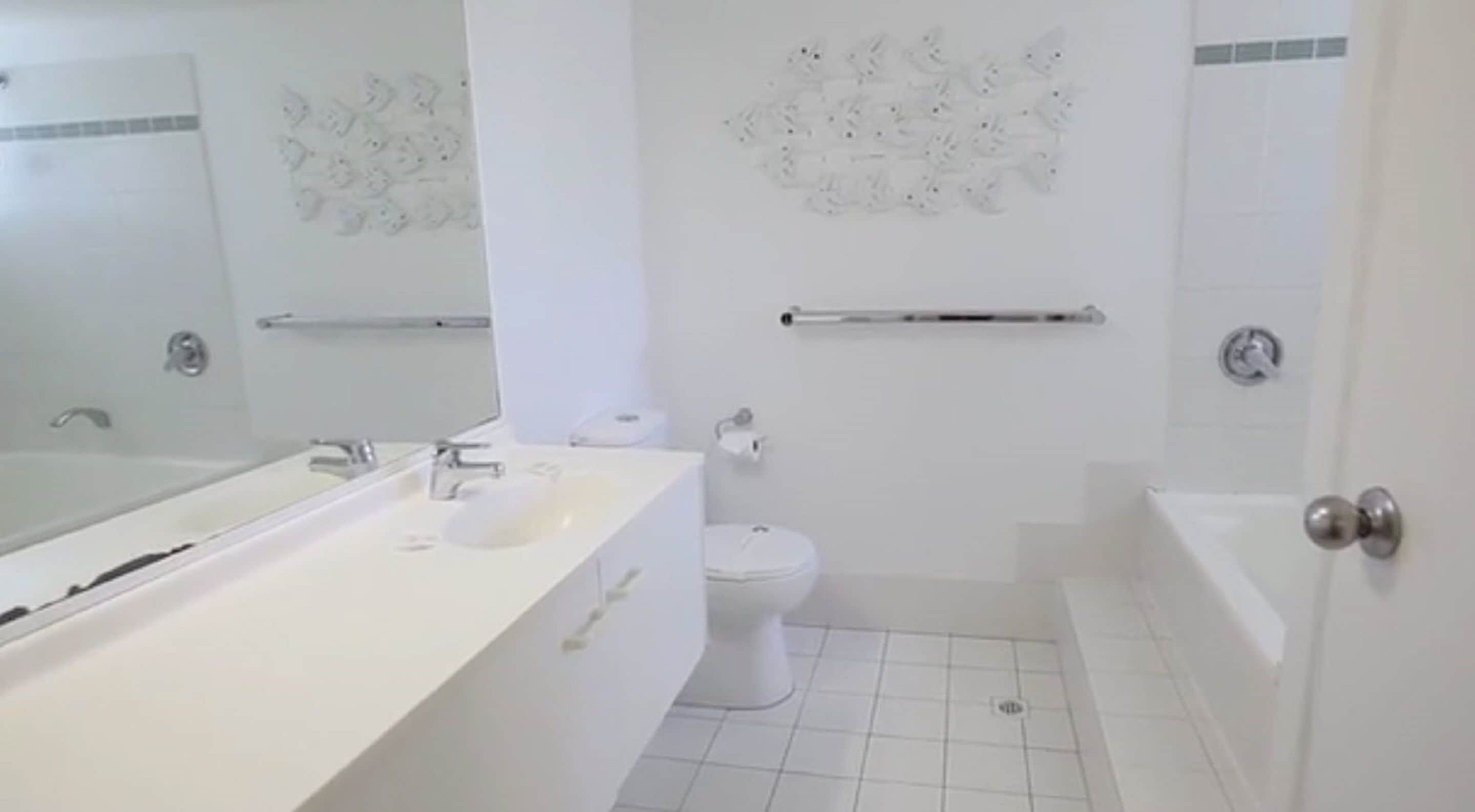 Een moderne badkamer met een witte wastafel, toilet en bad.