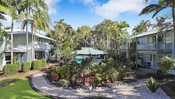 A resort with multiple buildings, a swimming pool, and lush tropical landscaping.