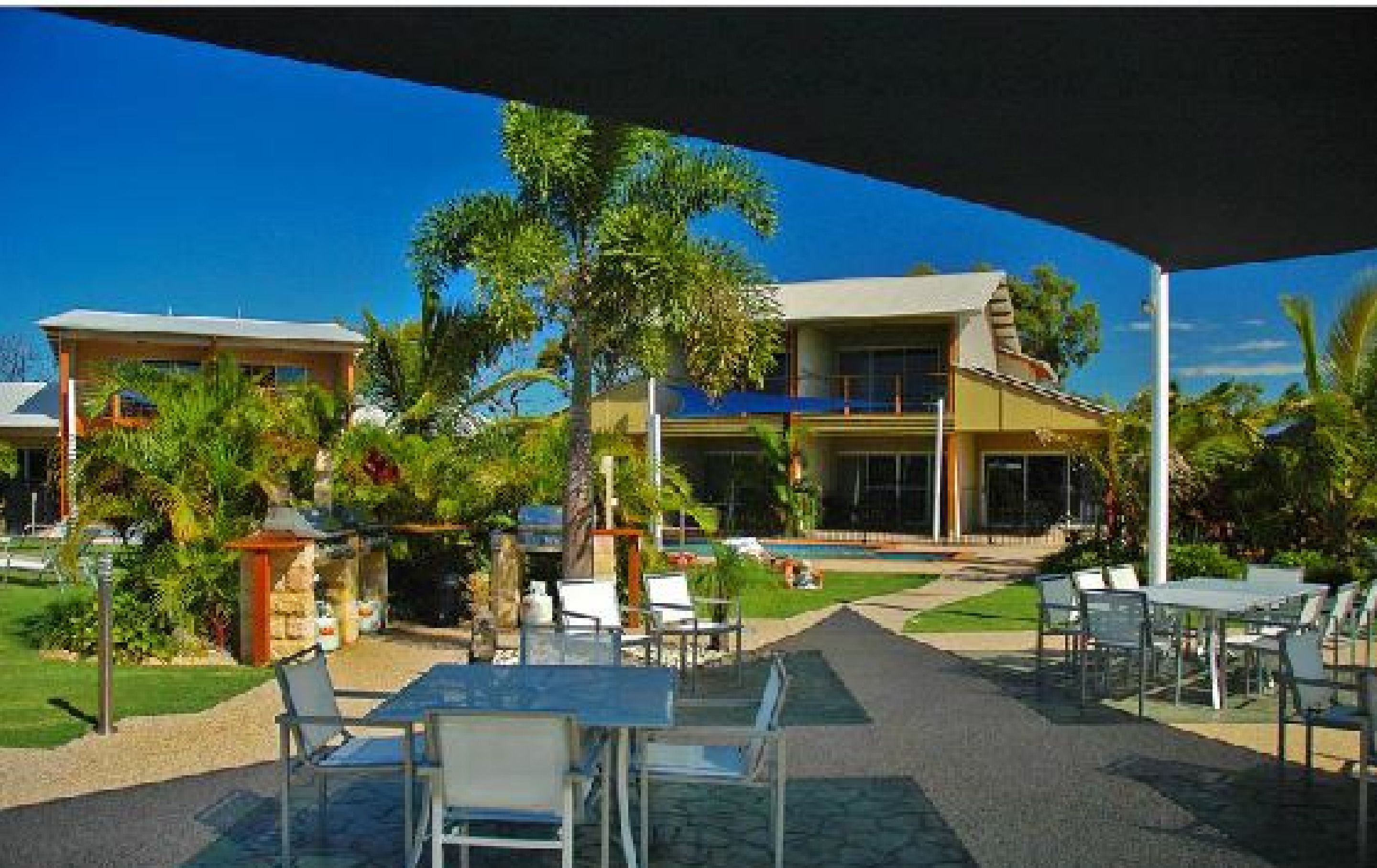 Ein Resort mit Außenbereich und Poolanlage, umgeben von üppiger Vegetation und Palmen.